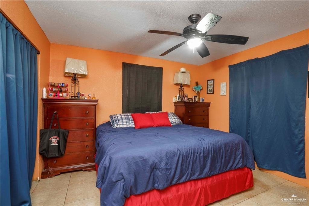 15 El Mesquite Lane Rio Grande City, TX 78582 - Photo 10 of 30 a bedroom with a bed and a chandelier