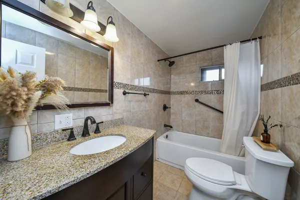 a bathroom with a granite countertop sink toilet and shower
