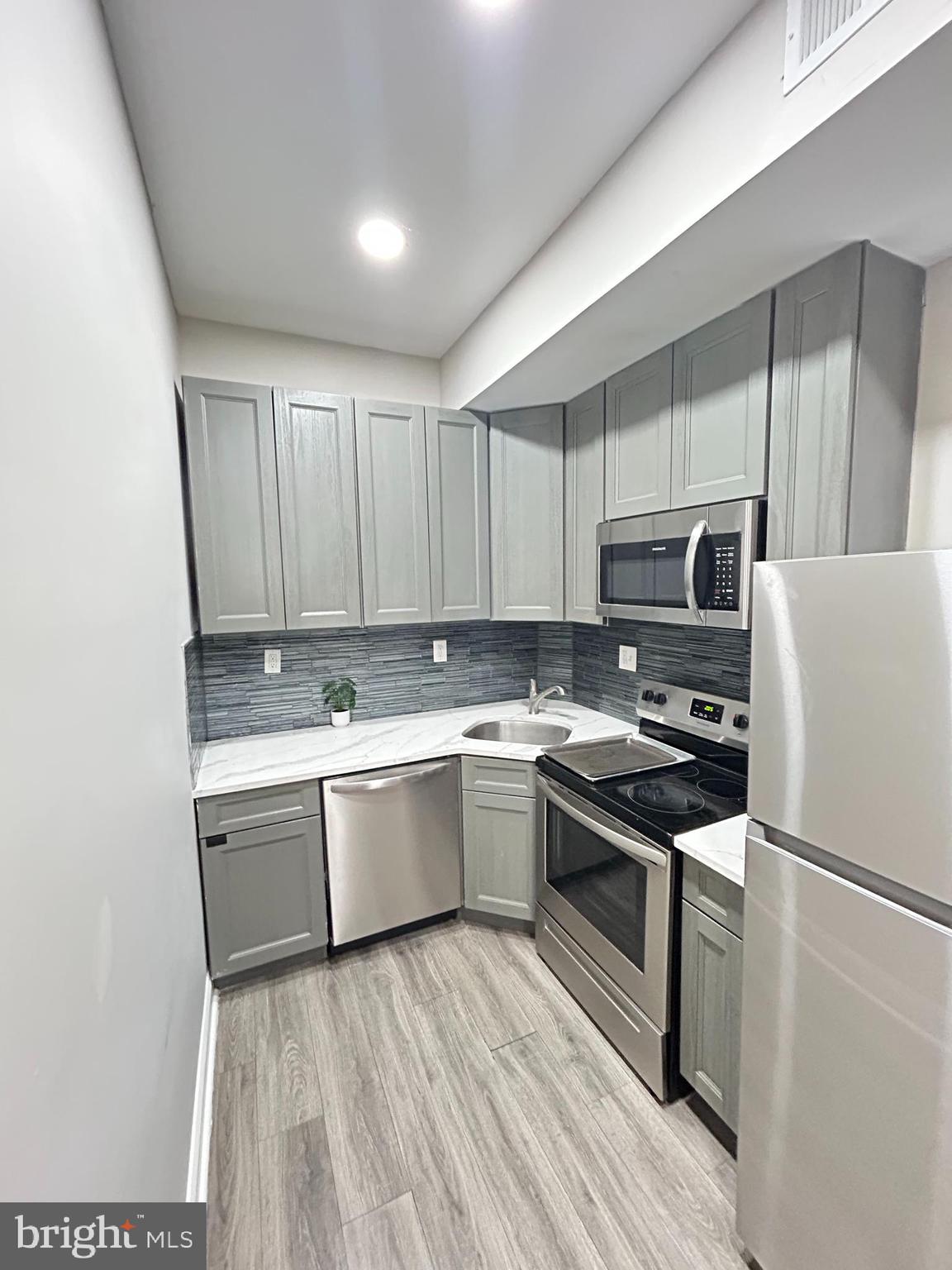 2417 North 54th Street, Unit A Philadelphia, PA 19131 - Photo 4 of 13 a kitchen with a sink a stove and refrigerator