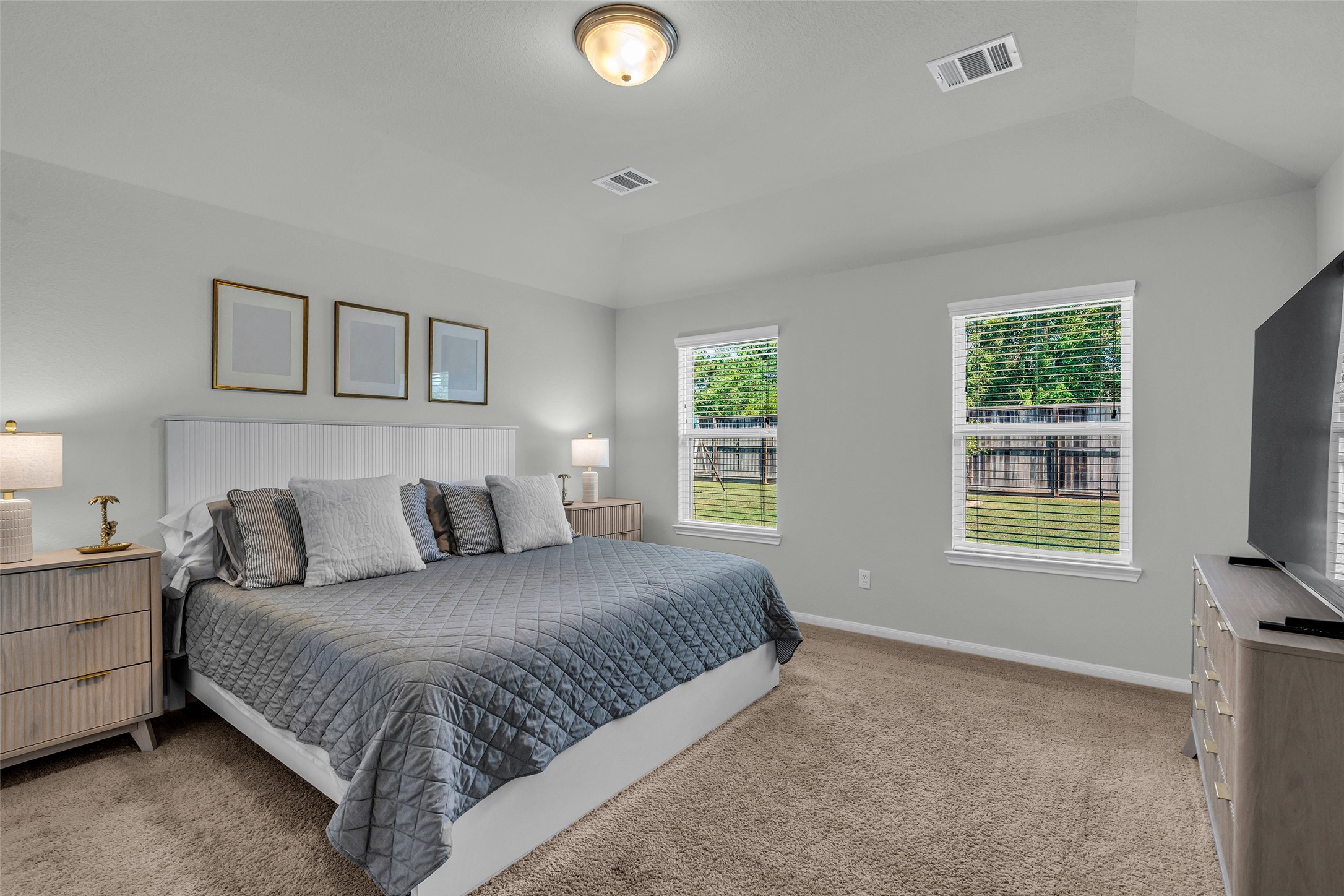 2344 Hagerman Road Conroe, TX 77384 - Photo 16 of 27 Spacious and inviting bedroom with plush carpeting, ample natural light from dual windows, and a cozy atmosphere highlighted by elegant decor and modern furnishings.