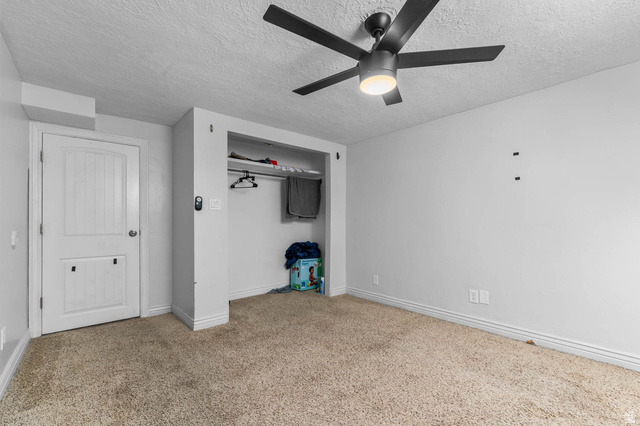 1489 North 400 West Bountiful, UT 84010 - Photo 29 of 47 Room with textured carpet flooring, a white paneled door, and an open closet