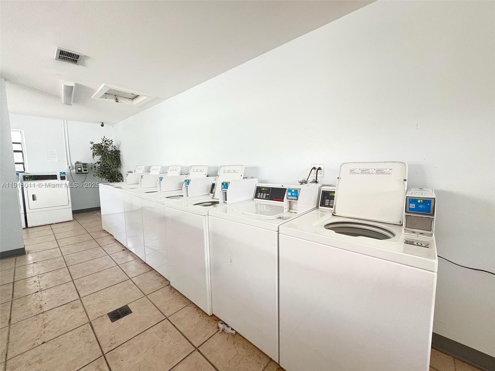 4022 Lakeside Drive, Unit 4022 Tamarac, FL 33319 - Photo 13 of 13 a room with a washing machine and a stove top oven