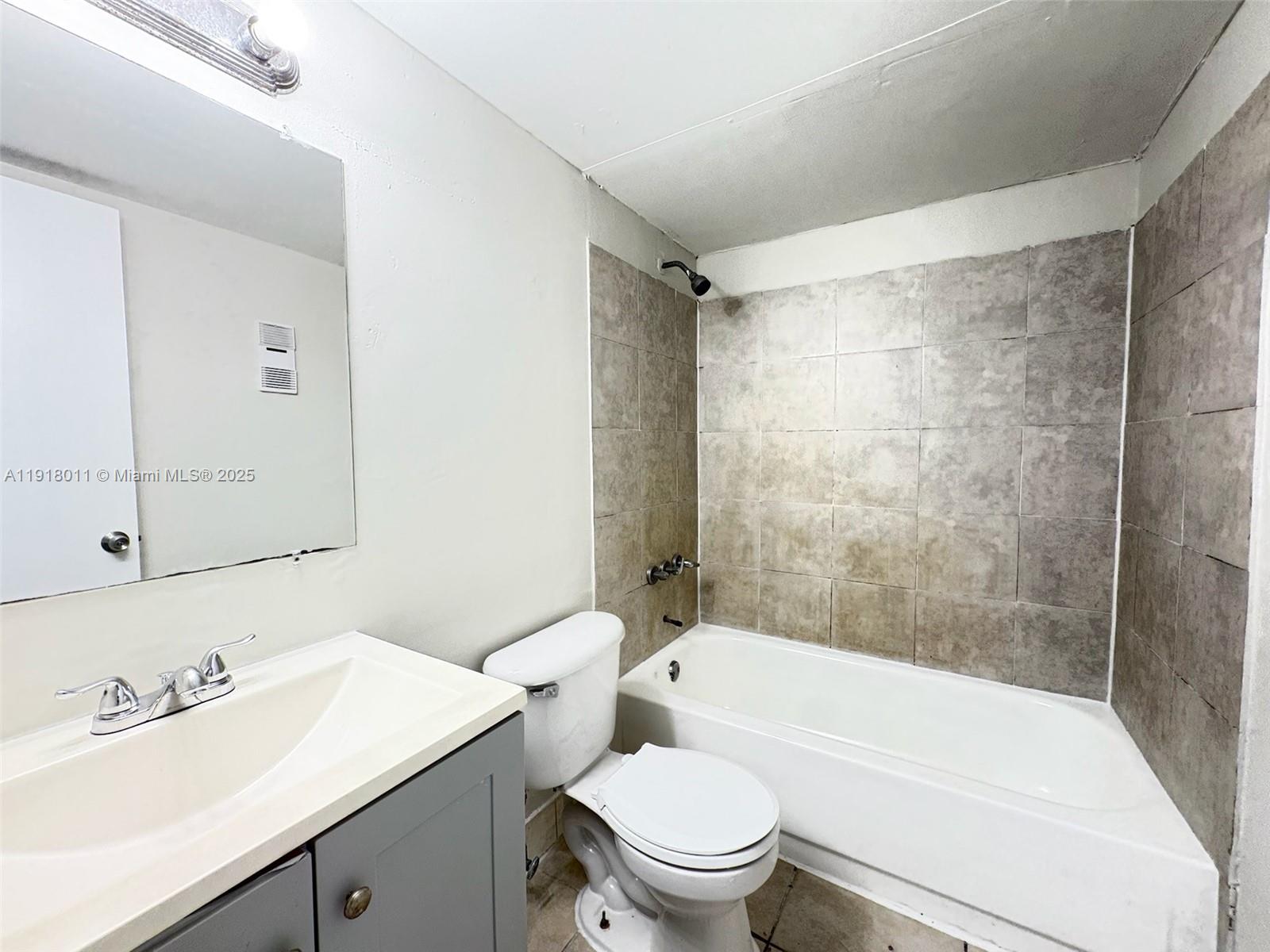 4022 Lakeside Drive, Unit 4022 Tamarac, FL 33319 - Photo 9 of 13 a bathroom with a sink a toilet and a bathtub