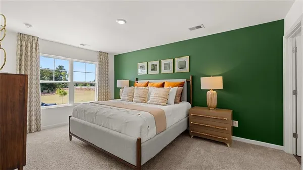 a bedroom with a bed lamp and a large window