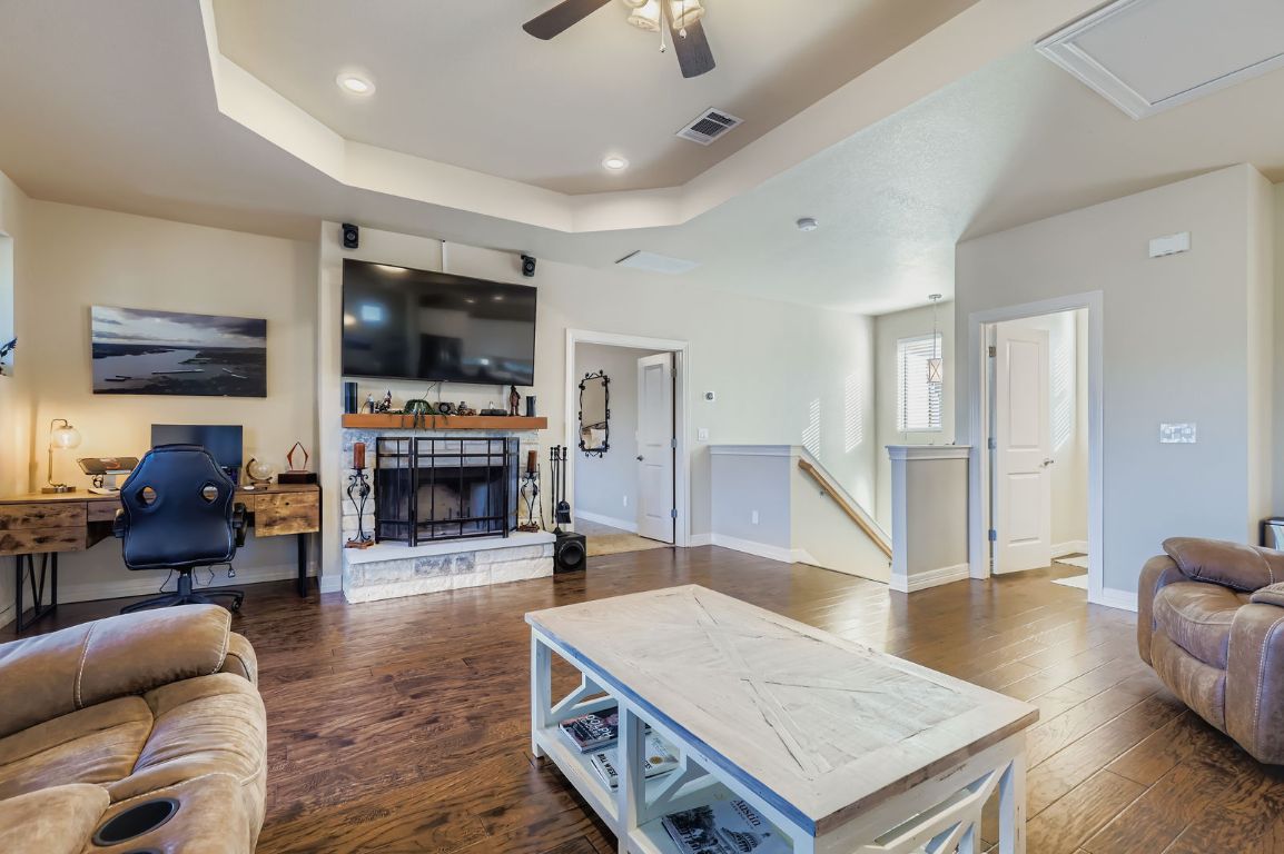 19004 Mariners Point Lago Vista, TX 78645 - Photo 14 of 23 a living room with furniture a fireplace and a flat screen tv