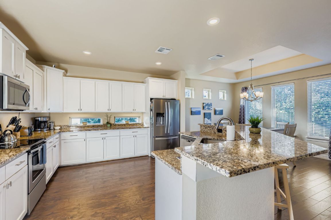 19004 Mariners Point Lago Vista, TX 78645 - Photo 2 of 23 a kitchen with kitchen island granite countertop stainless steel appliances a sink stove and cabinets