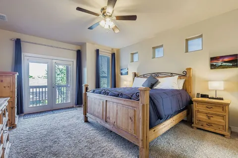 a bedroom with a bed a dresser and a chandelier