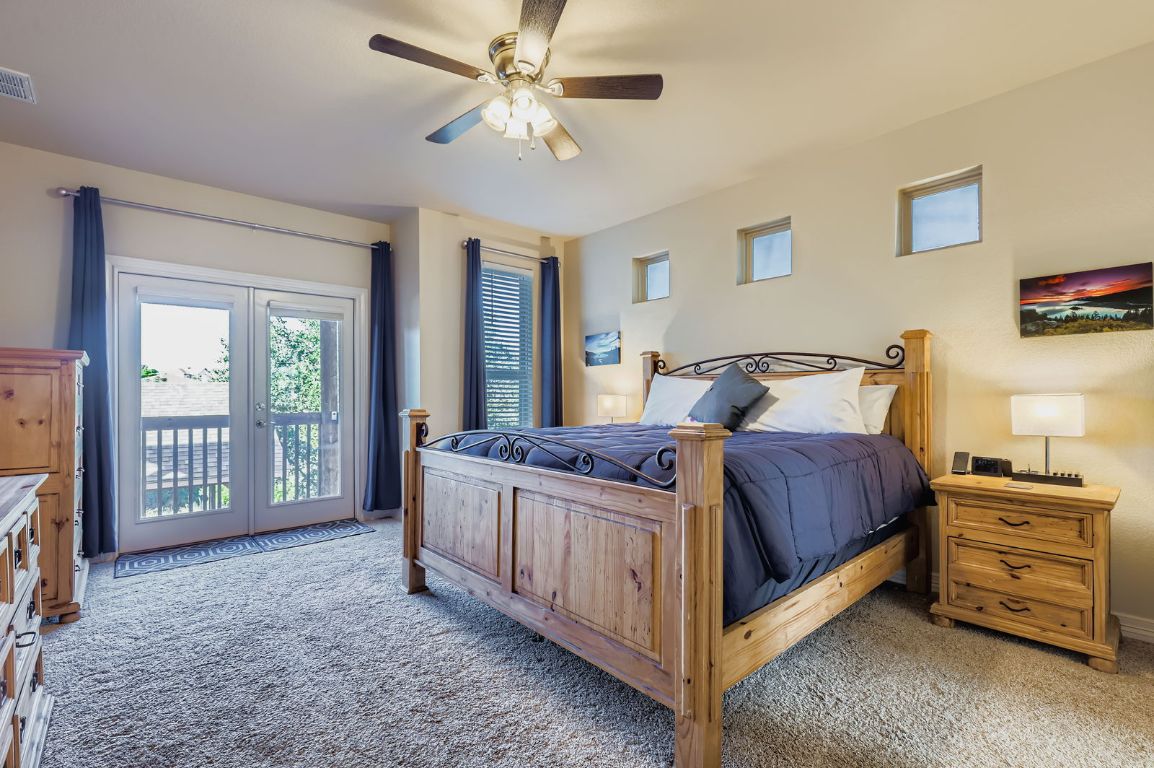 19004 Mariners Point Lago Vista, TX 78645 - Photo 3 of 23 a bedroom with a bed a dresser and a chandelier