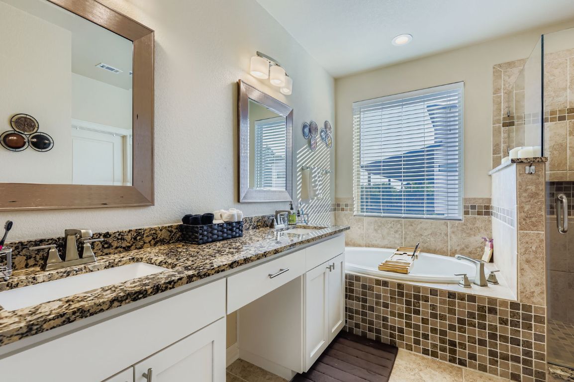 19004 Mariners Point Lago Vista, TX 78645 - Photo 9 of 23 a bathroom with a granite countertop sink mirror and a bathtub