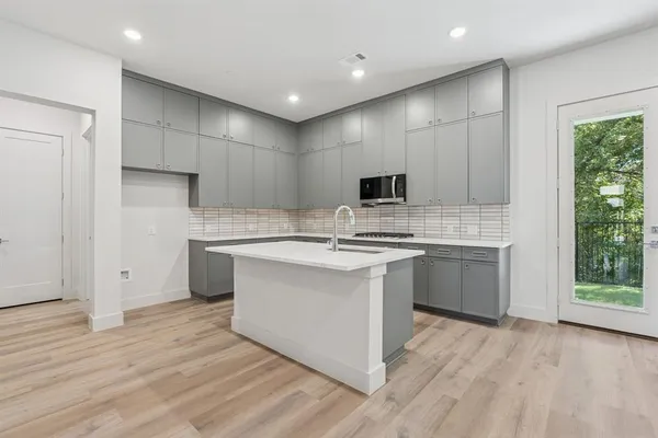 a kitchen with stainless steel appliances granite countertop a sink stove and microwave