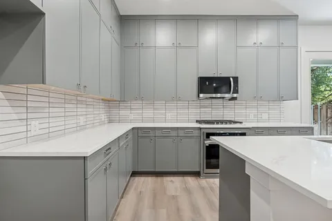 a kitchen with a sink stove top oven and cabinets