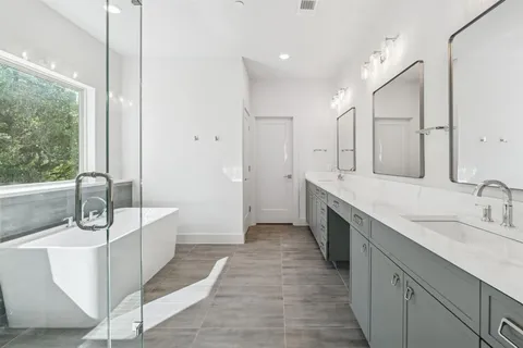 a bathroom with a tub sink shower and mirror