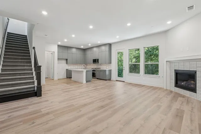 an empty room with wooden floor a fireplace and windows