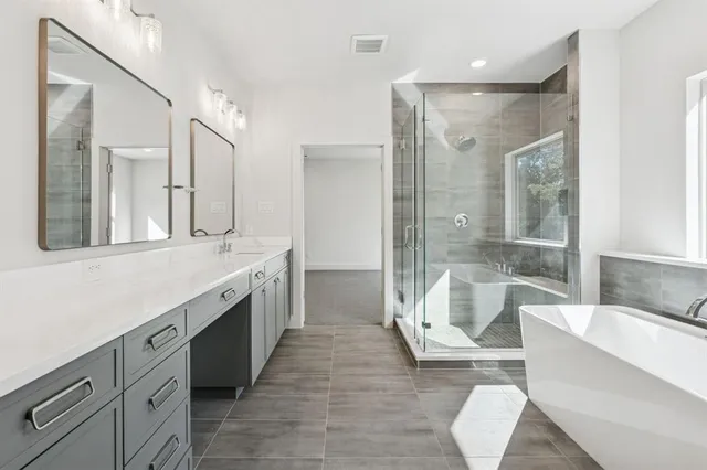 a spacious bathroom with a double vanity sink a large mirror and a bathtub