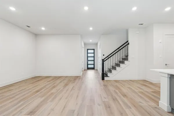 a view of kitchen with wooden floor electronic appliances and stairs