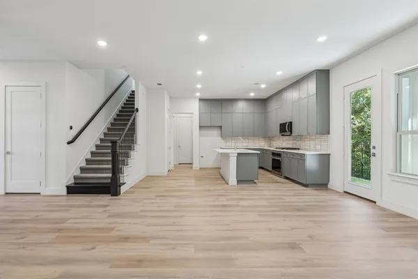 a large kitchen with a stove top oven a sink and dishwasher with wooden floor