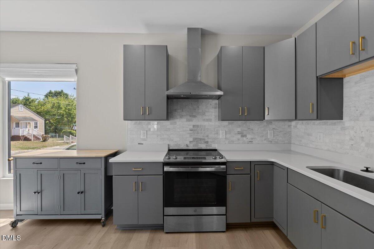 412 Commonwealth Street Durham, NC 27703 - Photo 12 of 24 a kitchen with stainless steel appliances granite countertop white cabinets and a stove