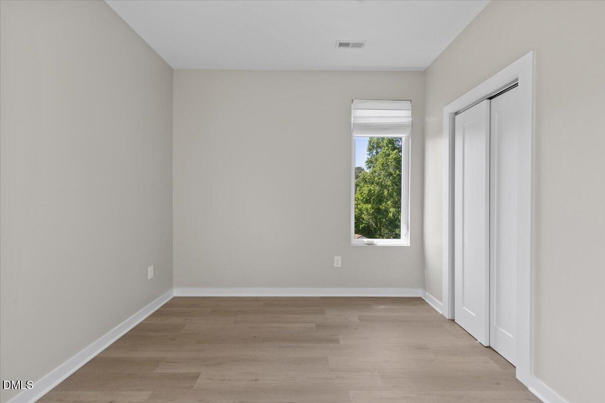 412 Commonwealth Street Durham, NC 27703 - Photo 15 of 24 an empty room with wooden floor and windows