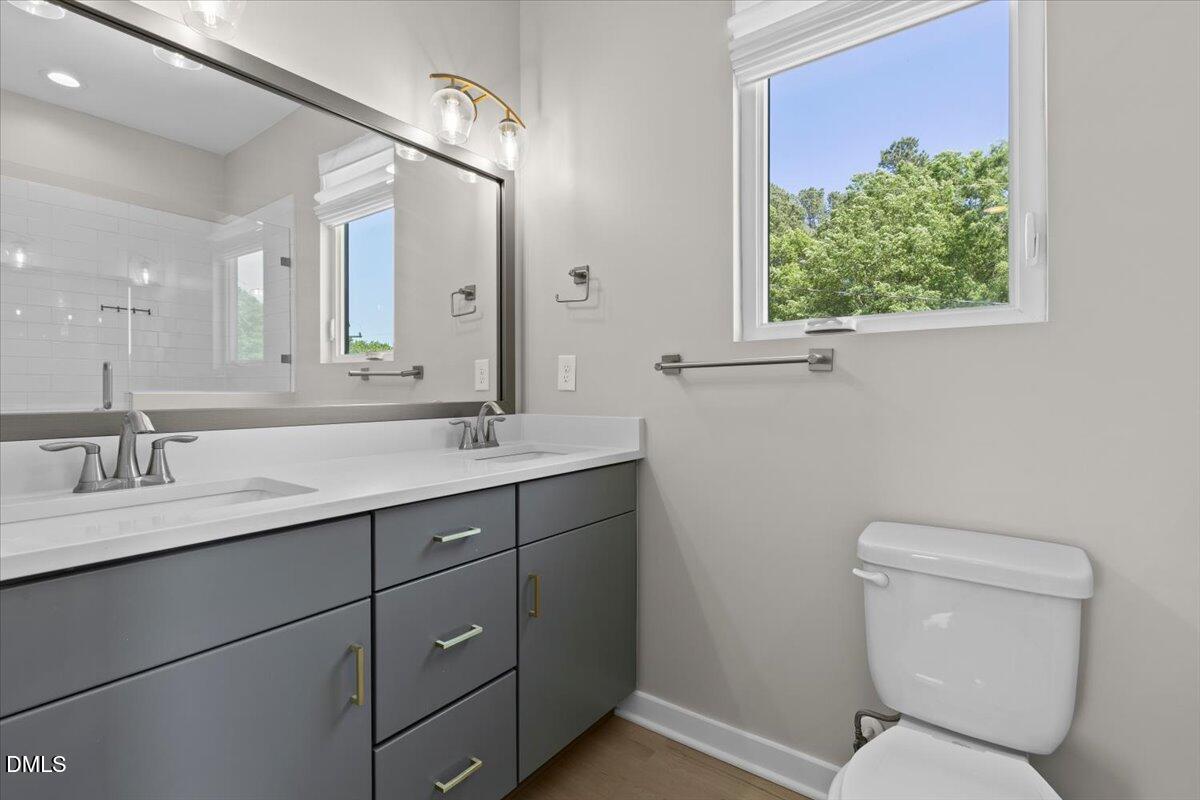 412 Commonwealth Street Durham, NC 27703 - Photo 16 of 24 a bathroom with a toilet sink and mirror
