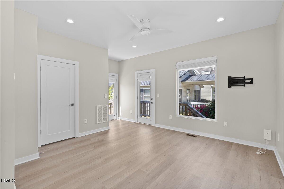 412 Commonwealth Street Durham, NC 27703 - Photo 4 of 24 an empty room with wooden floor and windows