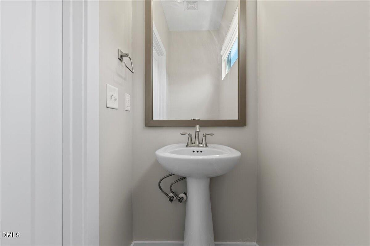 412 Commonwealth Street Durham, NC 27703 - Photo 7 of 24 a bathroom with a sink a mirror and shower