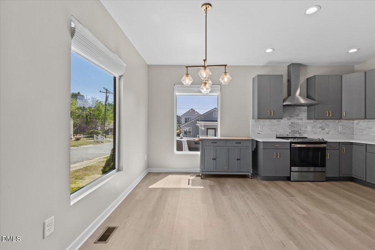 412 Commonwealth Street Durham, NC 27703 - Photo 9 of 24 a large kitchen with kitchen island a large counter top space a sink and stainless steel appliances