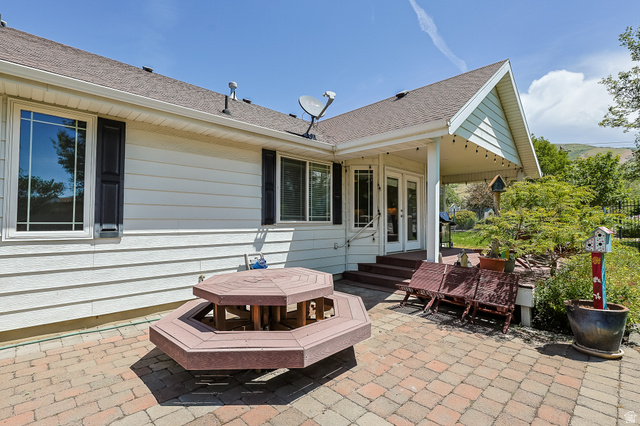 31 Village Square Road Centerville, UT 84014 - Photo 26 of 29 Rear exterior featuring a brick paver patio, covered porch, and white siding