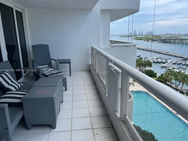 a view of two chairs and a table in a balcony