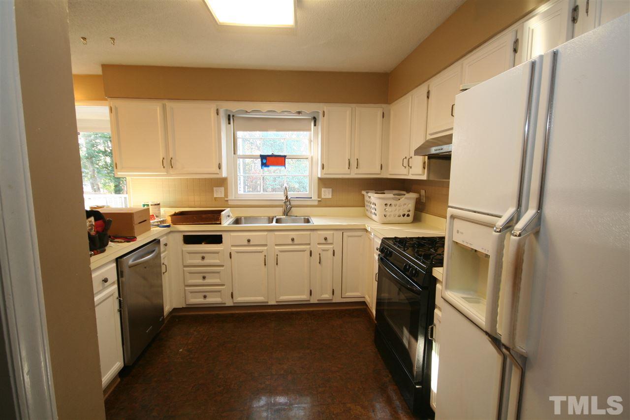 5821 Morning Forest Drive Raleigh, NC 27609 - Photo 7 of 25 a kitchen with white cabinets and white appliances