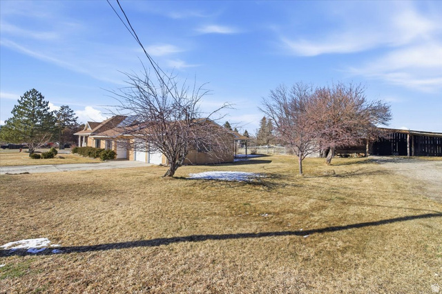217 East 400 South Spring City, UT 84662 - Photo 62 of 71 View of green lawn featuring driveway and an attached garage