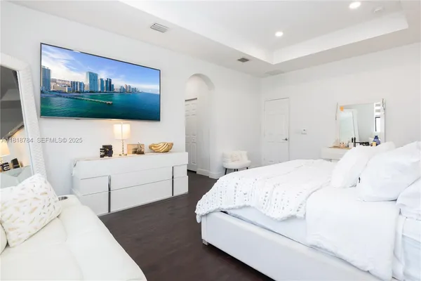 a bedroom with a bed and a flat screen tv