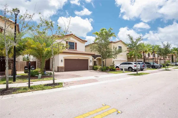 an aerial view of multiple houses with a city street