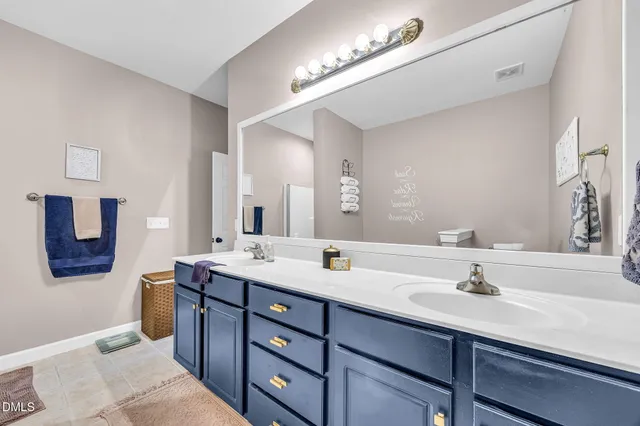a bathroom with a double vanity sink and a mirror