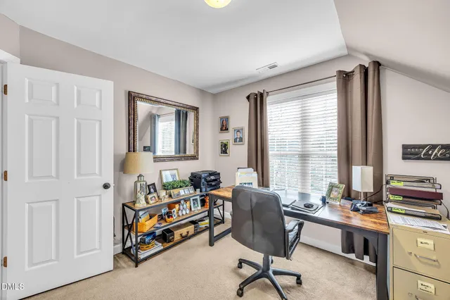 a view of a workspace with furniture and a window