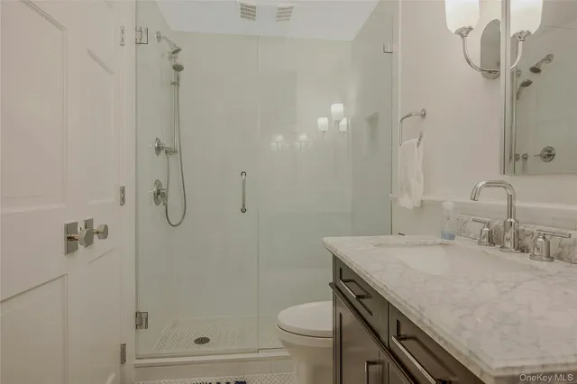 a bathroom with a granite countertop sink toilet and shower