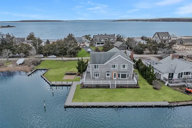 an aerial view of a house with a yard and lake view