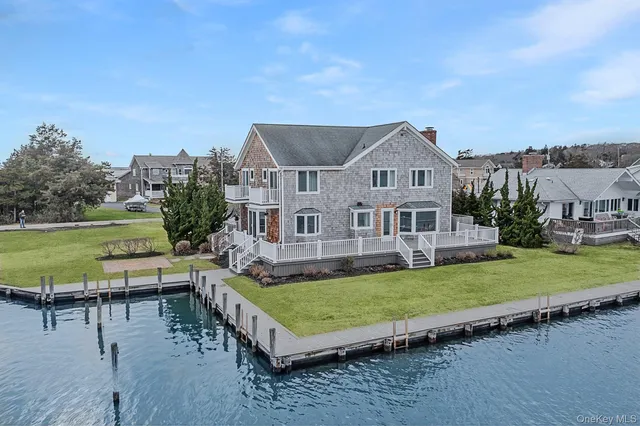 a view of a house with a big yard potted plants and large tree