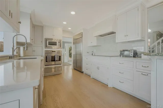 a kitchen with white cabinets and stainless steel appliances