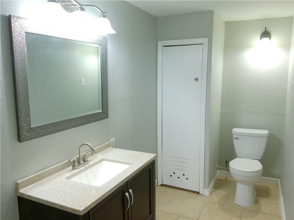 3921 Chestnut Street, Unit B Corpus Christi, TX 78411 - Photo 4 of 5 a bathroom with a sink toilet and mirror
