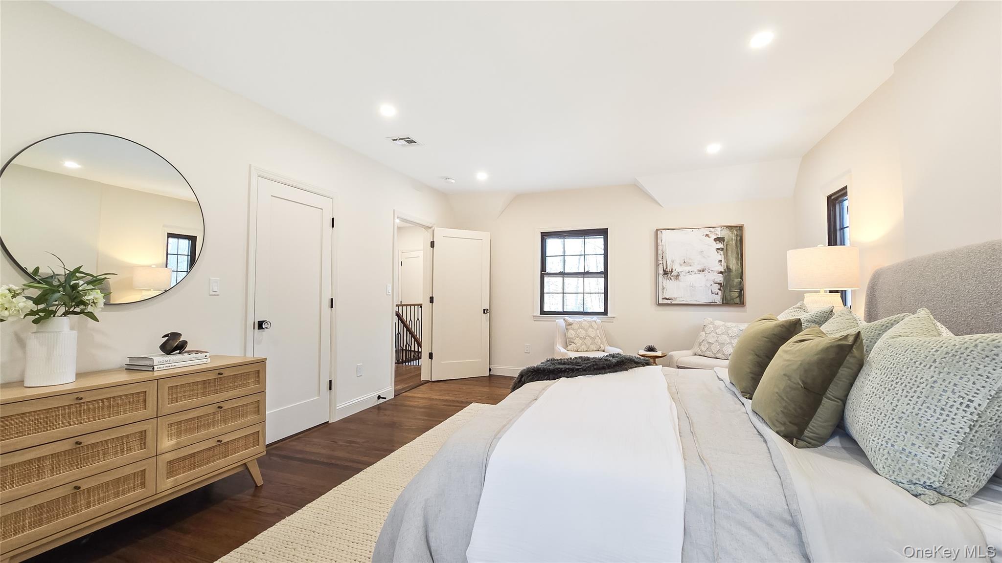 18 Lakeside Drive New Rochelle, NY 10801 - Photo 23 of 43 a spacious bedroom with a bed a mirror and lamp