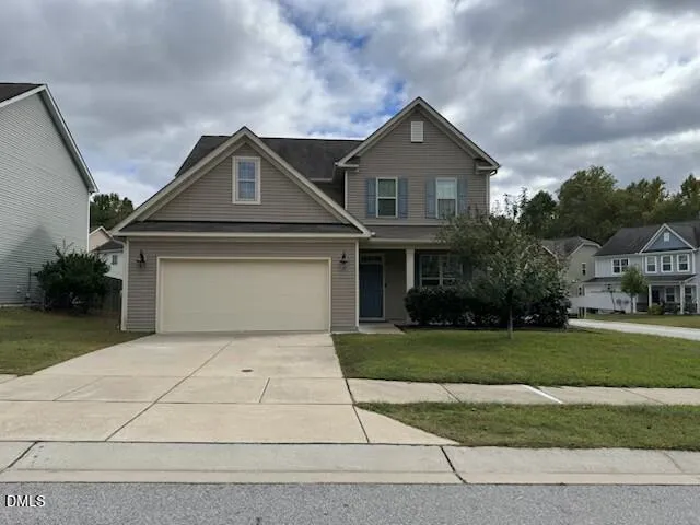 a front view of a house with a yard and garage