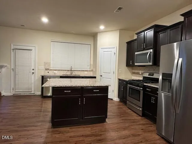 a kitchen with stainless steel appliances granite countertop a stove a sink dishwasher a refrigerator and a oven