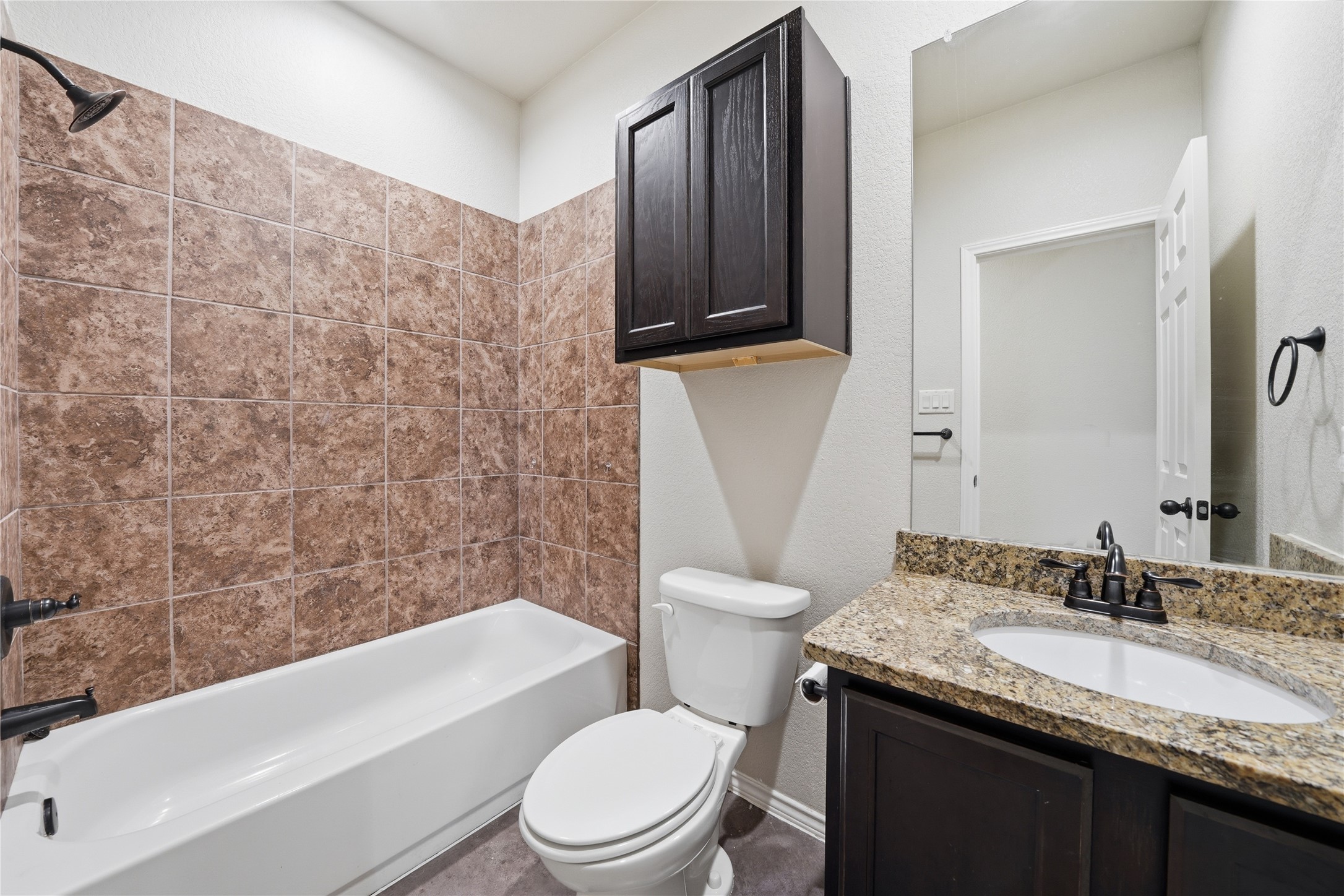 533 Jack Rabbit Lane, Unit A Buda, TX 78610 - Photo 25 of 34 A well-appointed bathroom features a bathtub, toilet, and a vanity with granite counters.