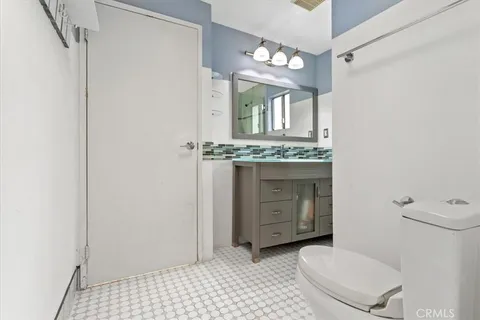 a bathroom with a toilet a sink and mirror