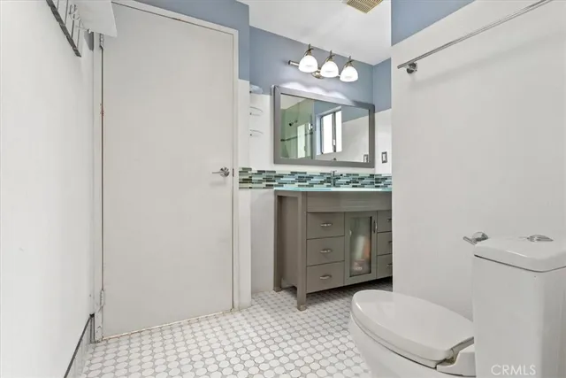 a bathroom with a toilet a sink and mirror