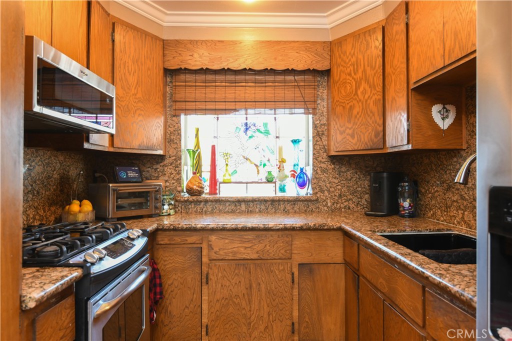 4616 North Roxburgh Avenue Covina, CA 91722 - Photo 7 of 23 a kitchen with stainless steel appliances granite countertop a stove and a microwave