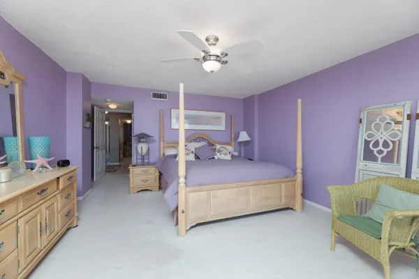 a spacious bedroom with a bed and a chandelier