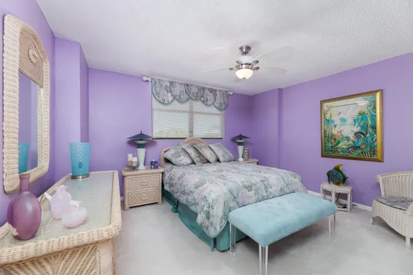 a spacious bedroom with a bed and a chandelier