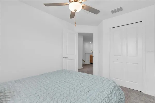 a bedroom with a bed and a chandelier fan