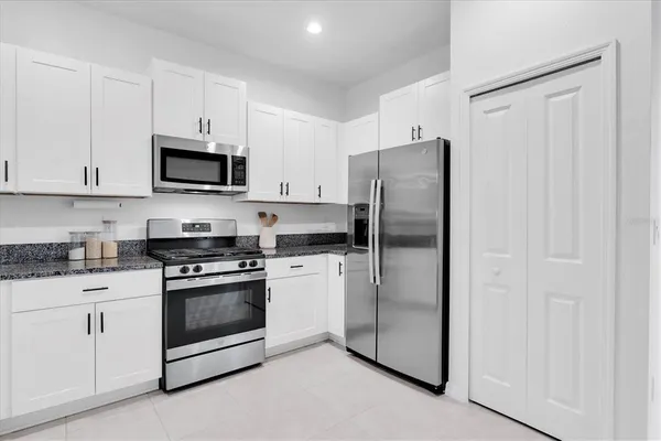 a kitchen with stainless steel appliances granite countertop a refrigerator stove a sink and a granite counter tops